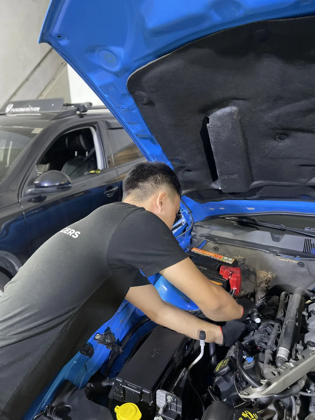 Underchargers mechanic working on a Ford Mustang engine